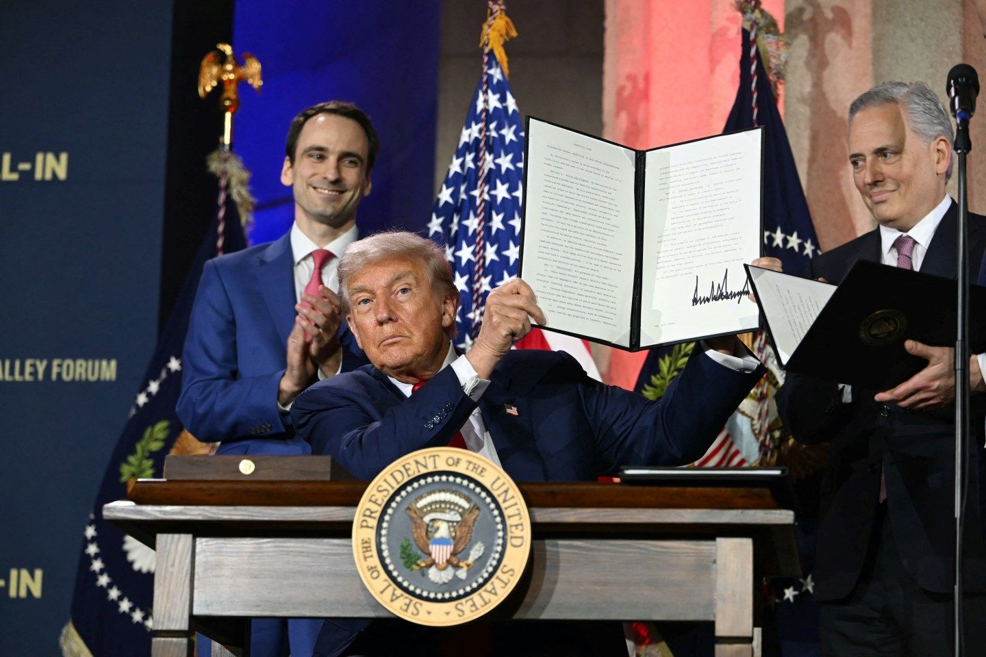 U.S. President Donald Trump displays an executive order on artificial intelligence he signed at the "Winning the AI Race" AI Summit at the Andrew W. Mellon Auditorium in Washington, D.C.., on July 23.