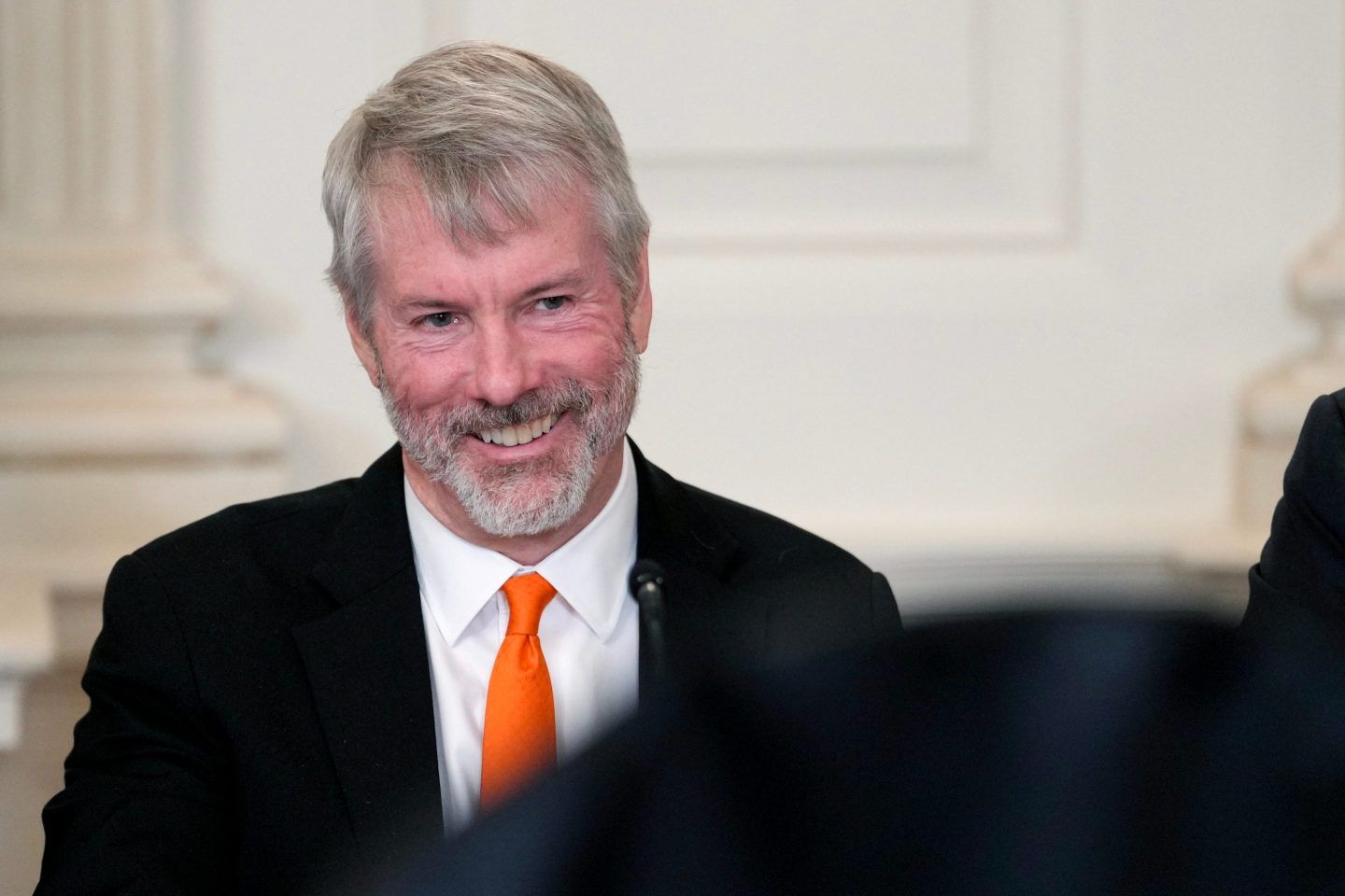 Michael Saylor smiles at the camera during a White House media event.