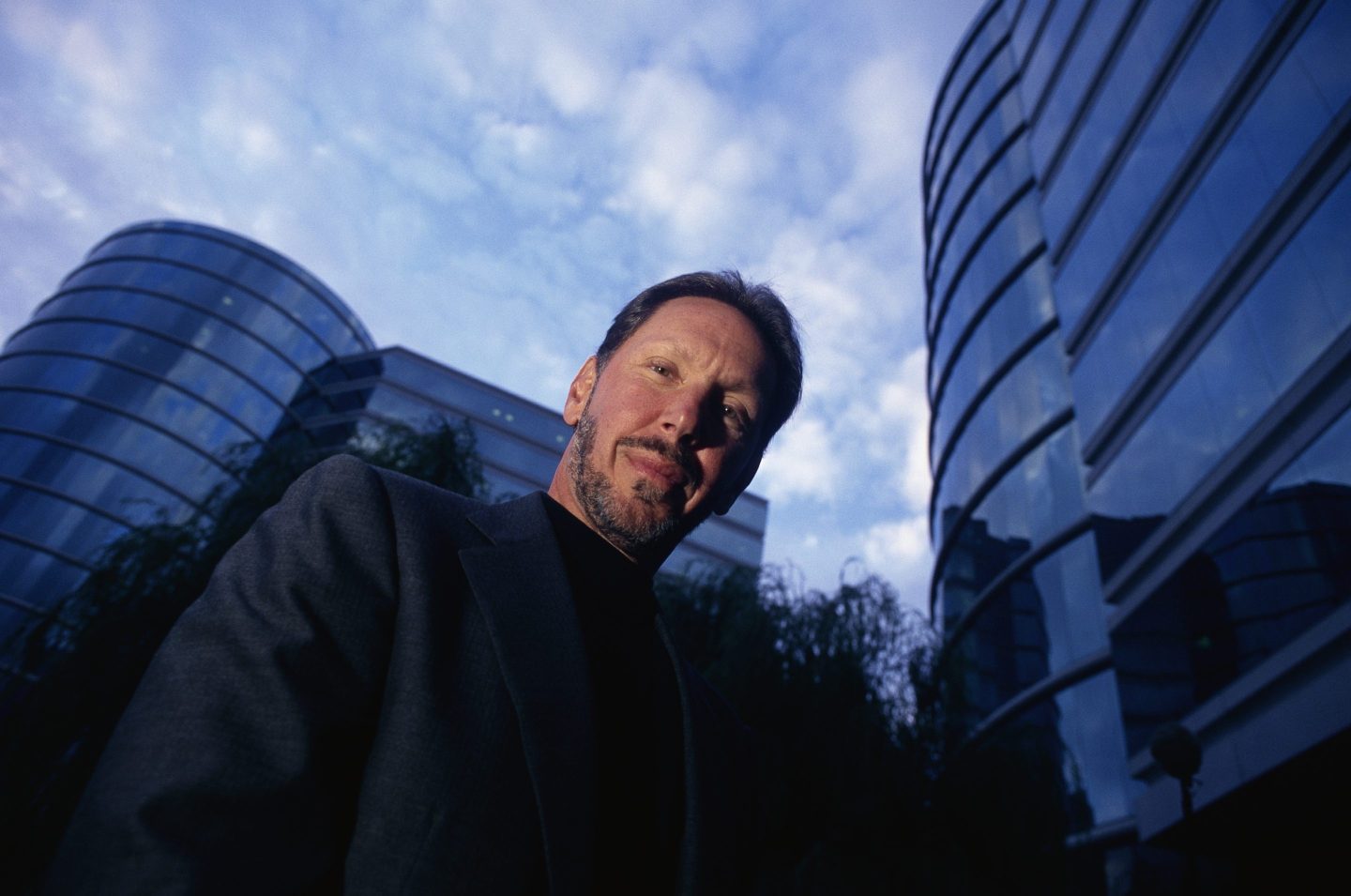 Larry Ellison with buildings behind him