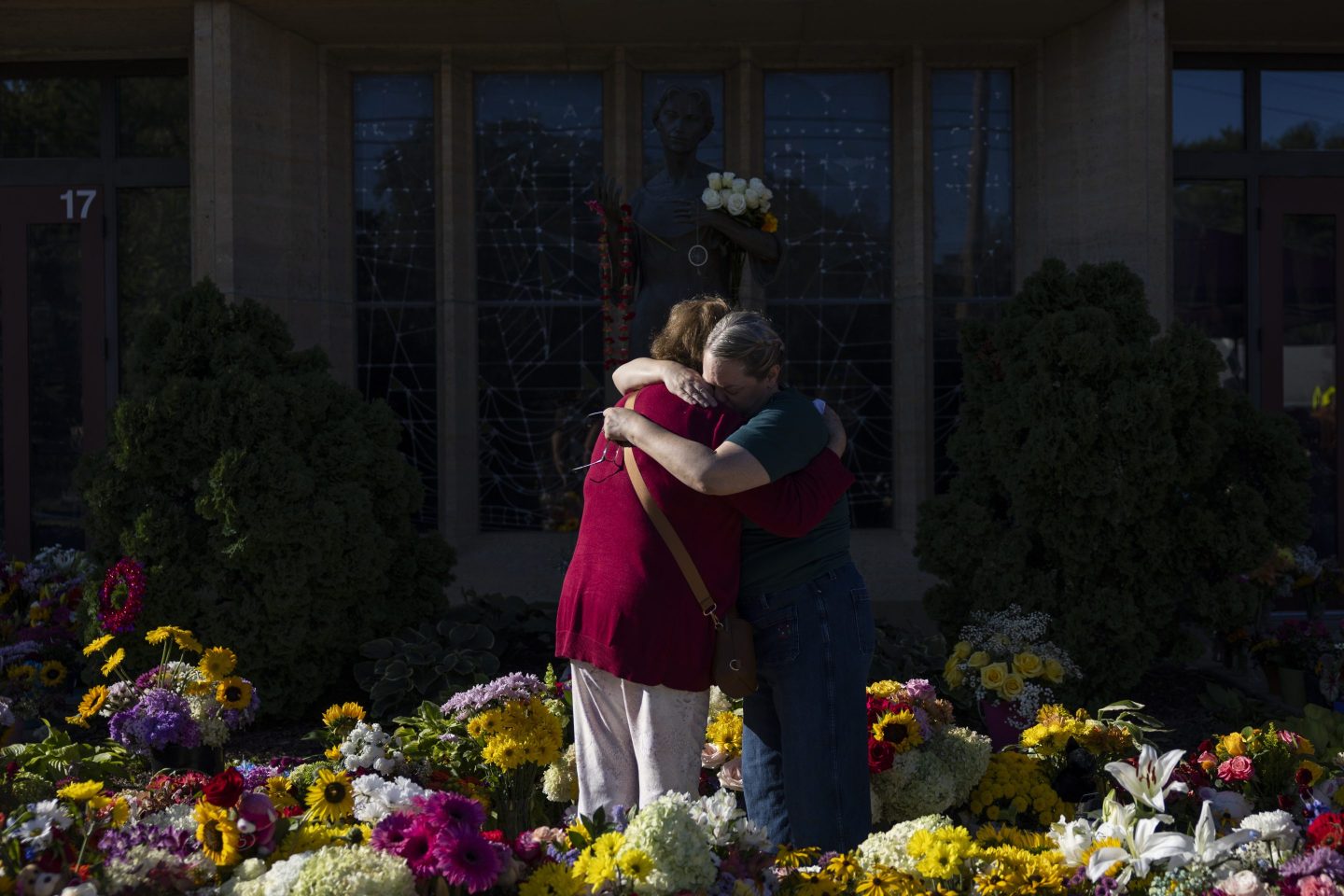 Women embrace at the memorial outside the Annunciation Catholic Church following Wednesday's shooting at the school, Sunday, Aug. 31, 2025, in Minneapolis.