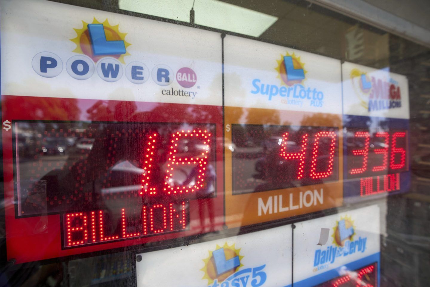 An electronic sign reads $1.8 billion as crowds wait in line to buy lottery tickets at the Bluebird Liquor store in Hawthorne, Calif., on Friday.