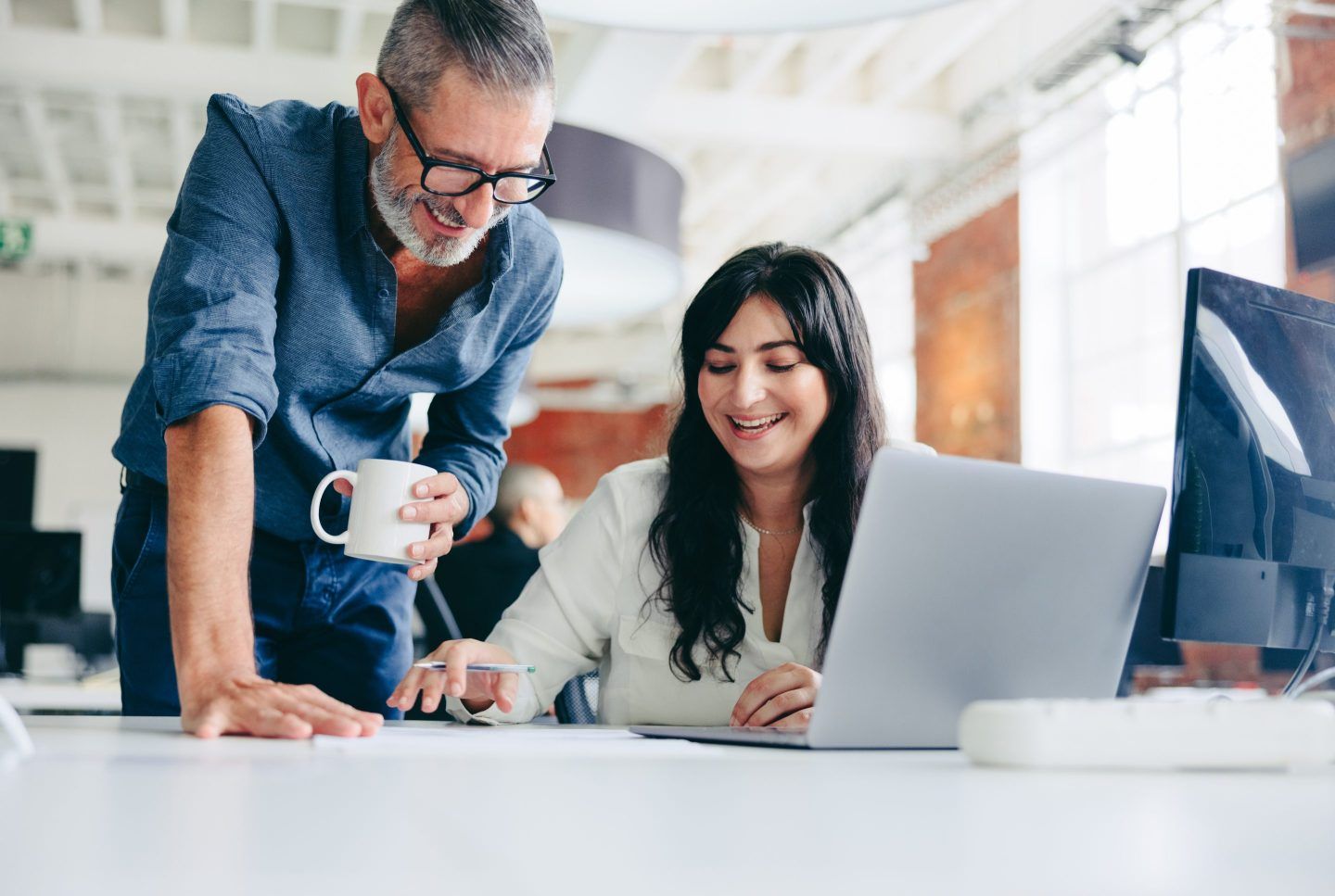 Woman with colleague at her desk