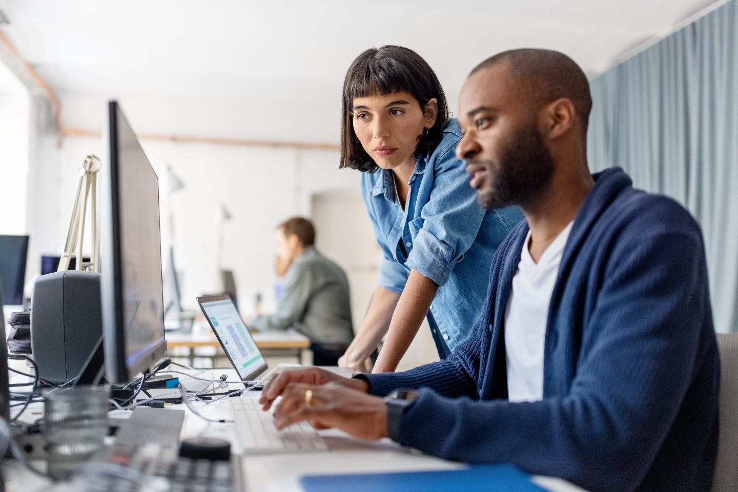 Two employees stare at a computer at the office.