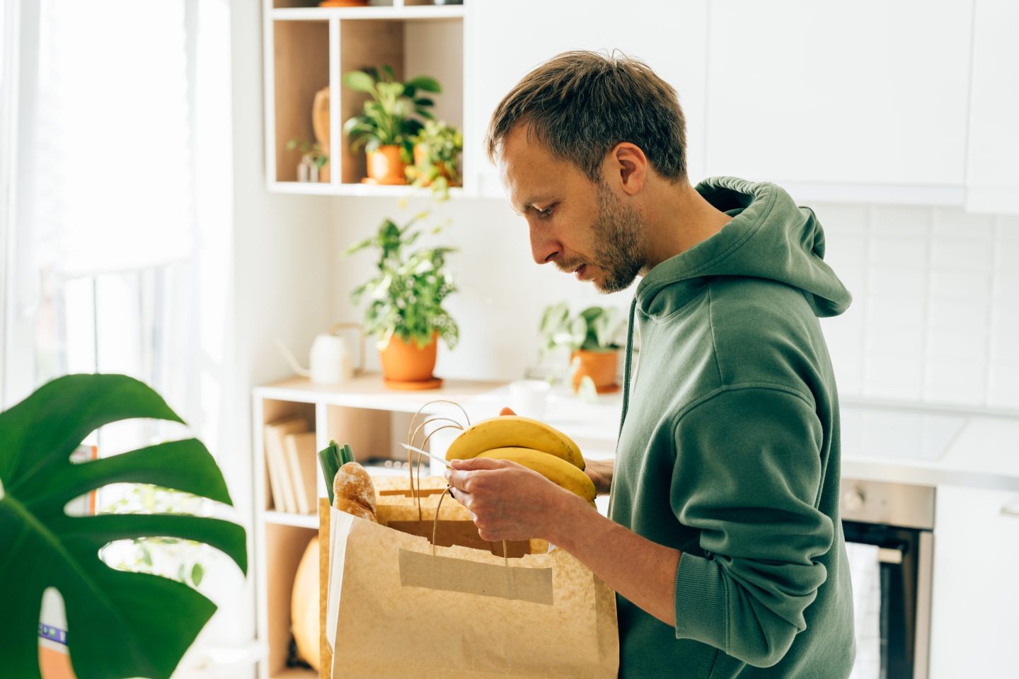 Middle aged male frustrated while looking banana and receipt from grocery store.