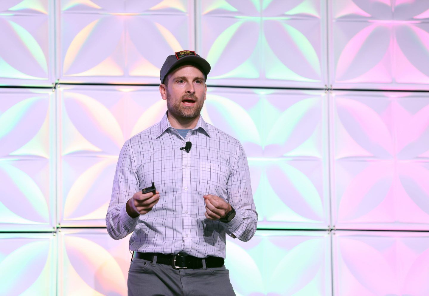 Ben Mabey stands on a stage with an opal-colored background.