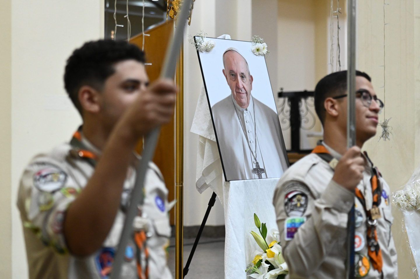 Egyptian boy scouts attend a service, with the late Pope Francis' photo in the background, for the late Pope at the Holy Virgin Mary Coptic Catholic Cathedral on April 22, 2025 in Cairo, Egypt.