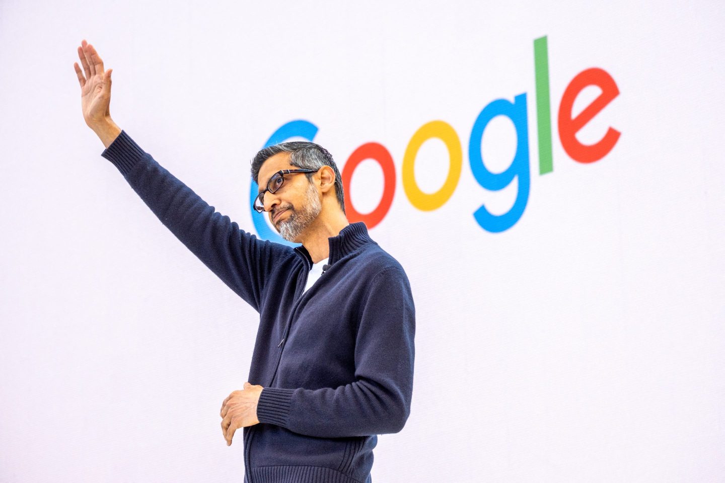 Google CEO waves on stage at a May conference.