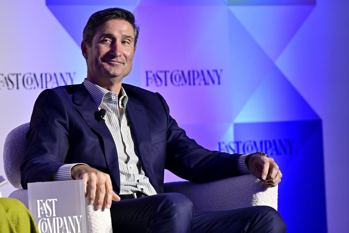 Brian Niccol smirks in a chair