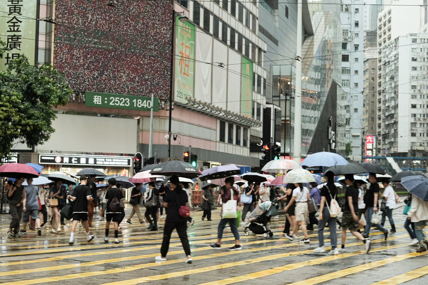 People walk with umbrellas as unstable weather and heavy rain continue on September 20, 2025 in Hong Kong, China. 