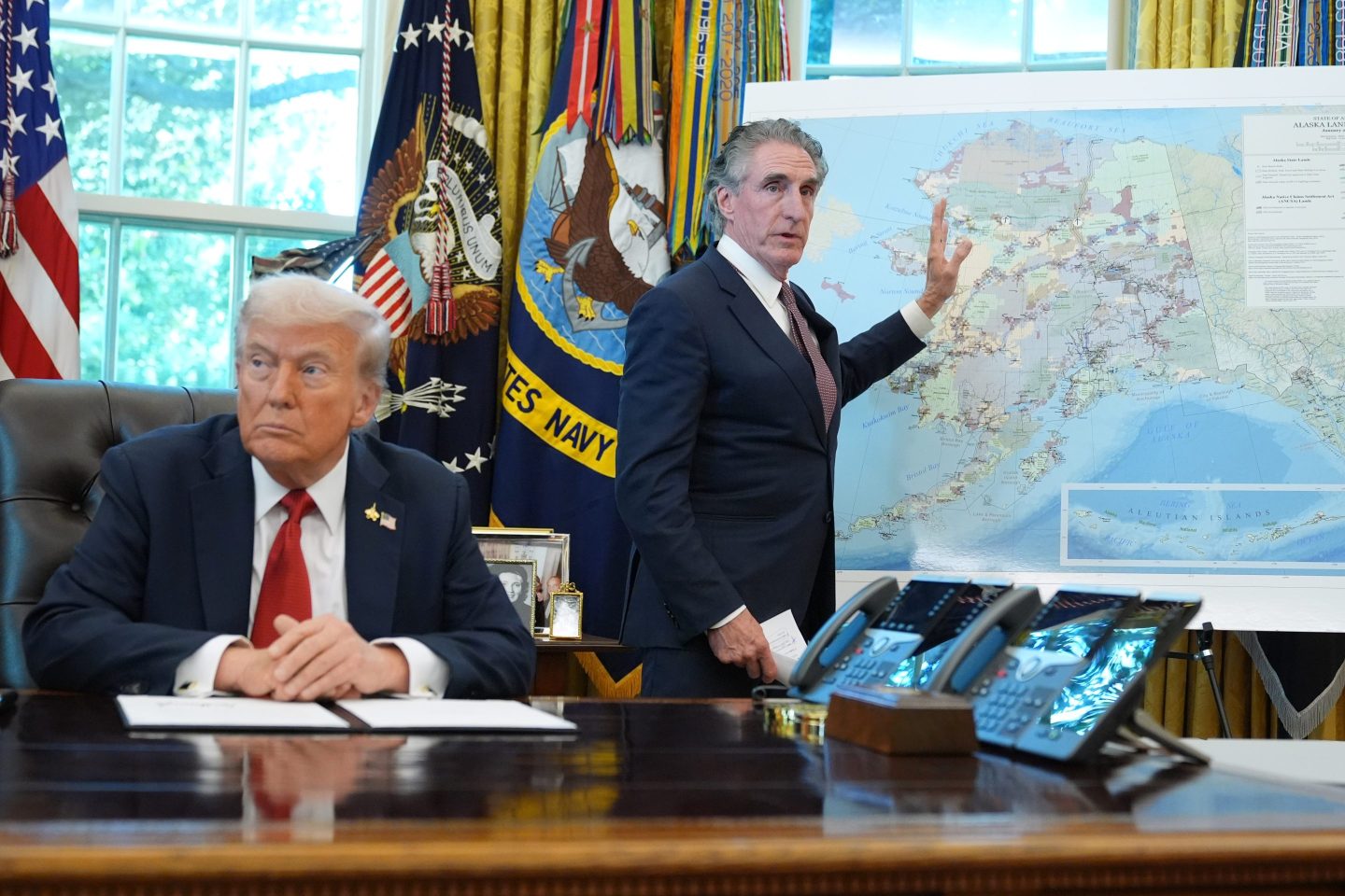 President Donald Trump listens as Interior Secretary Doug Burgum speaks to reporters in the Oval Office at the White House, Monday, Oct. 6, 2025, in Washington.