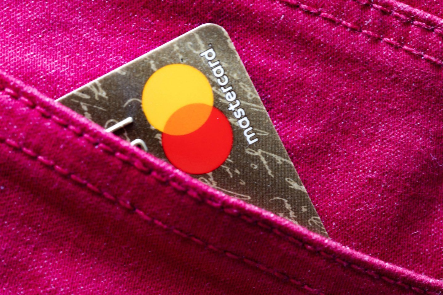 A Mastercard credit card peeking out from a pocket.