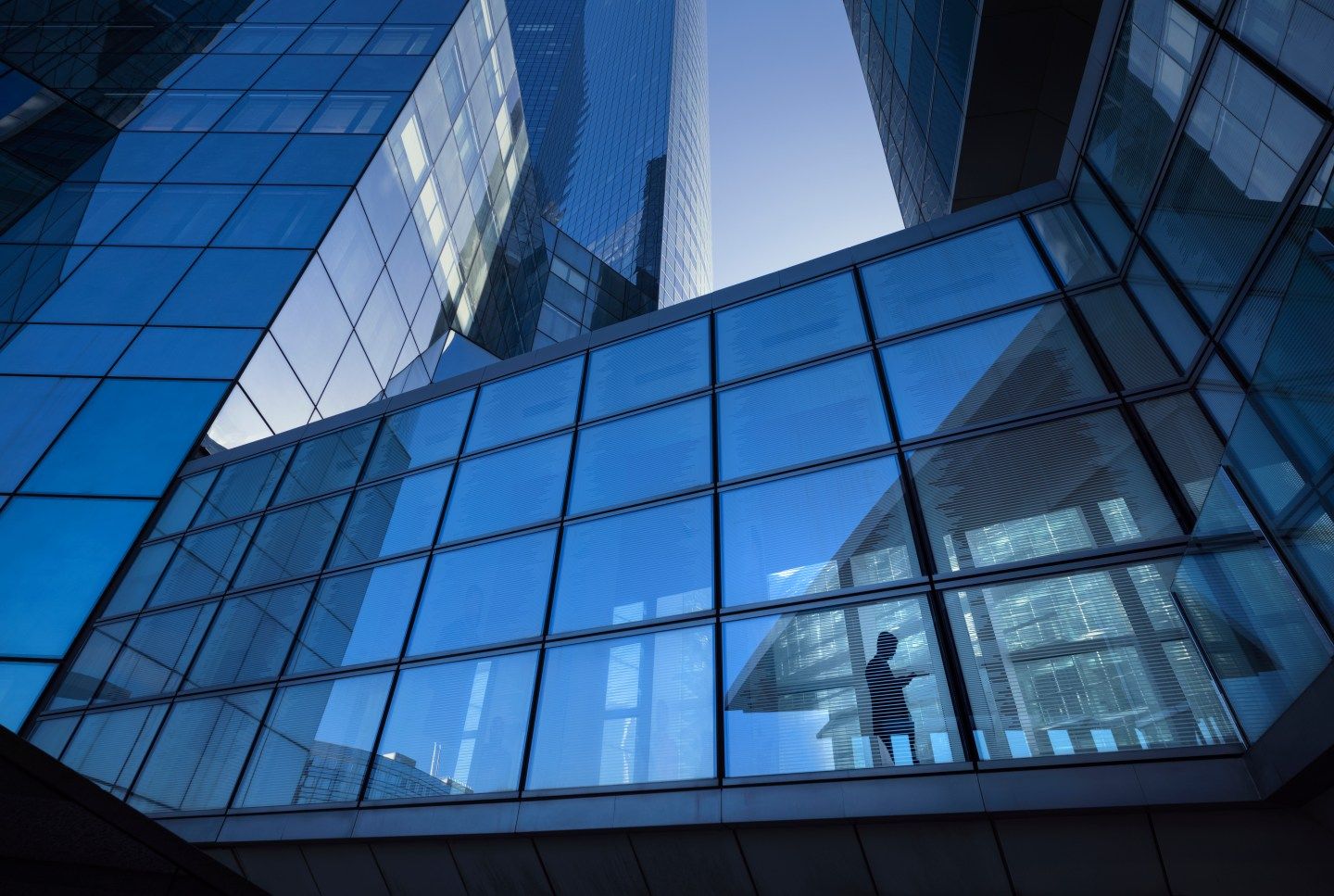 person sitting in corner office glass building