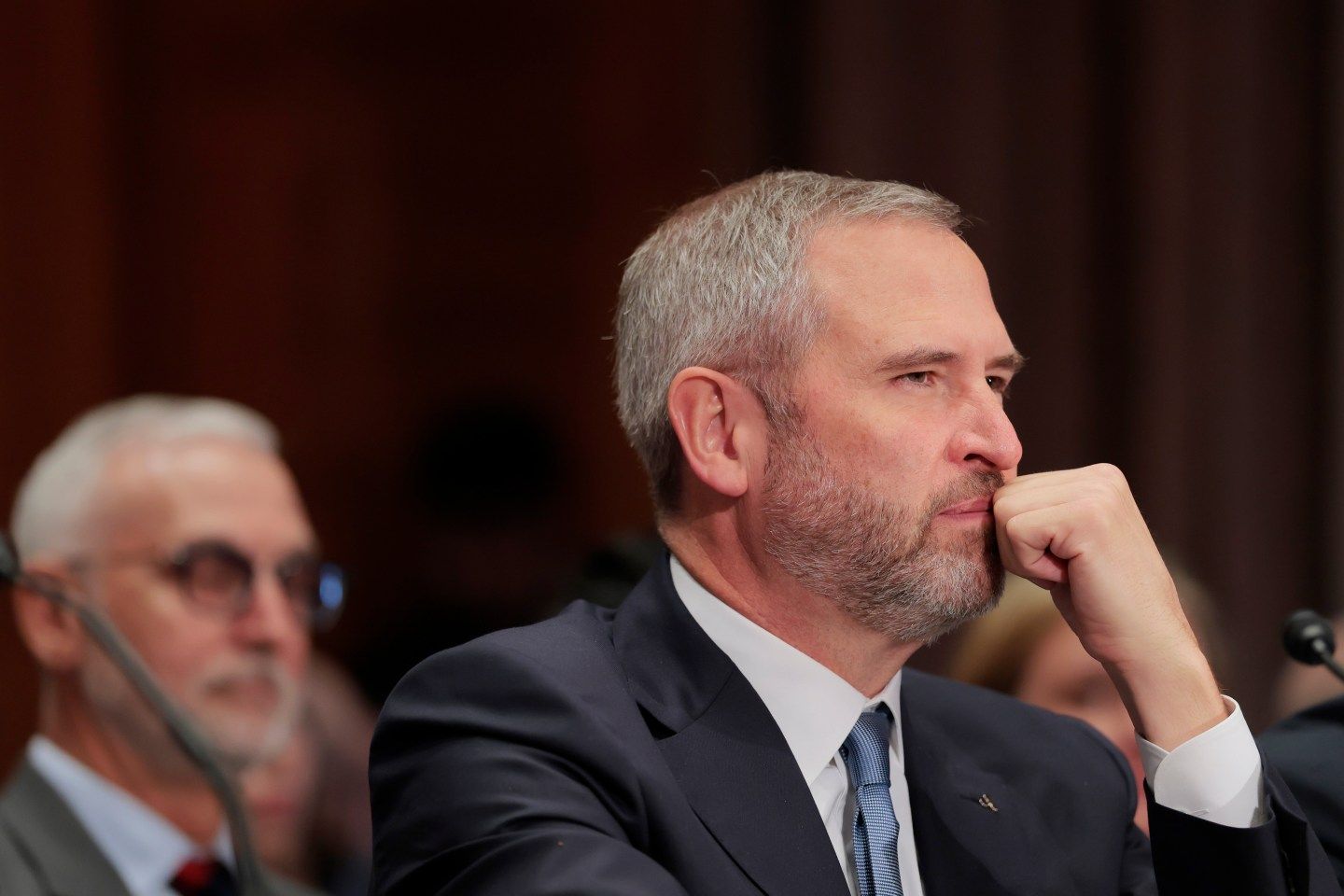 Ripple CEO puts head on hand during Senate hearing.