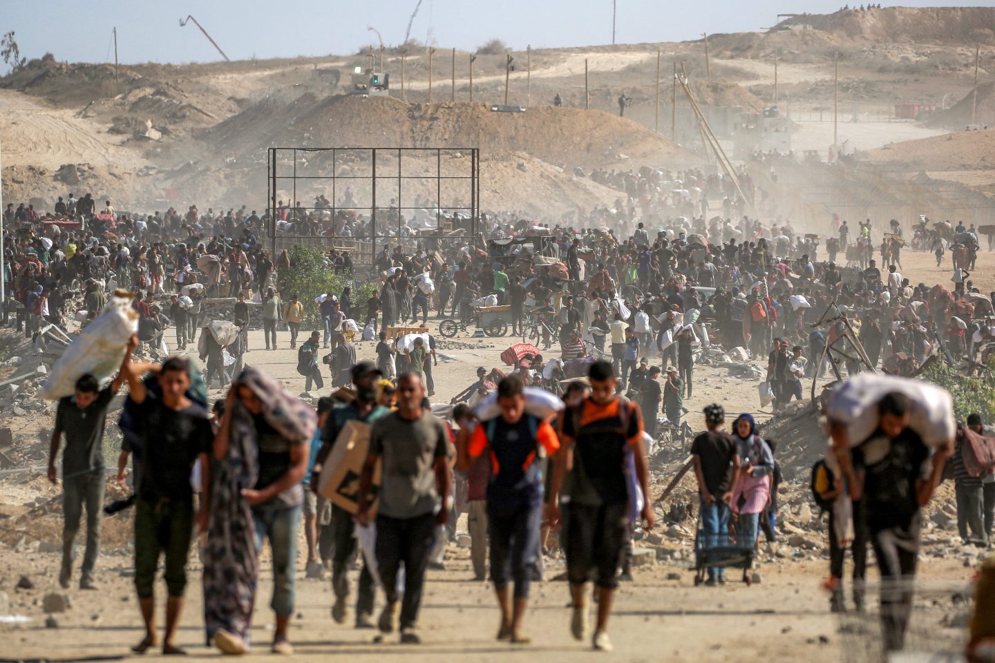 People walk with humanitarian aid packages that they received from a distribution centre run by the US and Israeli-backed Gaza Humanitarian Foundation, at the so-called "Netzarim corridor", in Nuseirat in the central Gaza Strip, on Sept. 30.