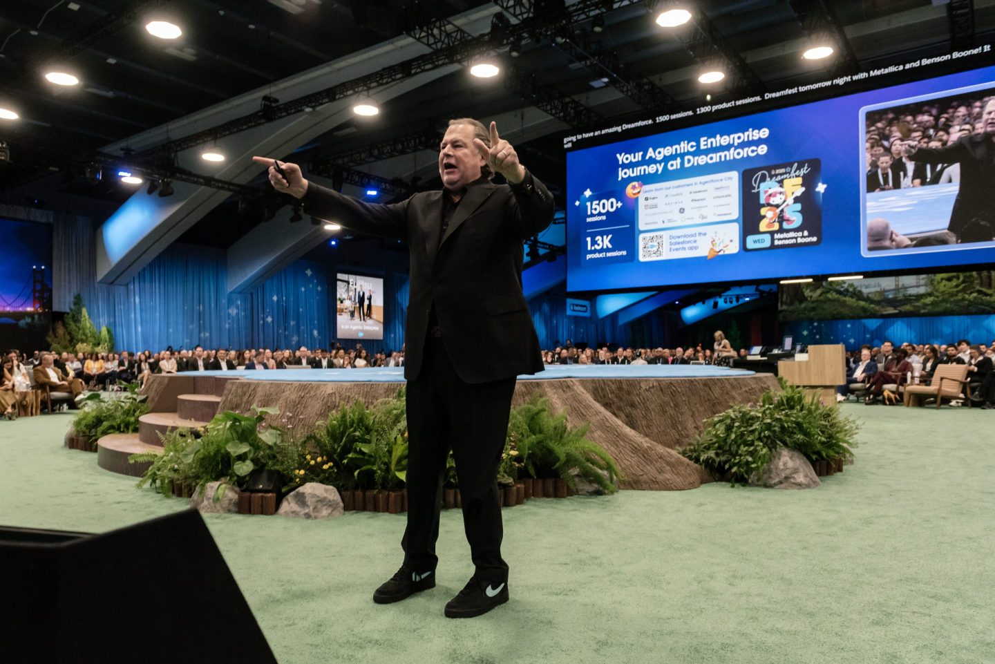 Salesforce founder and CEO Marc Benioff on stage at the company's Dreamforce conference, pointing with both hands.