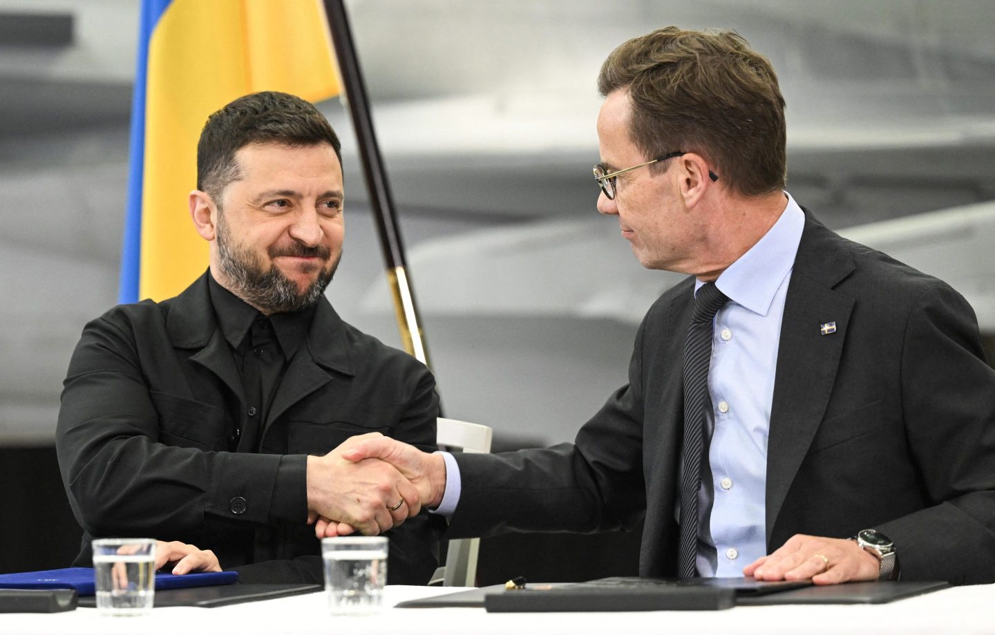 Swedish Prime Minister Ulf Kristersson (R) and Ukrainian President Volodymyr Zelensky shake hands as they signed an agreement in Linköping, Sweden, on October 22, 2025, where they discussed defense cooperation.
