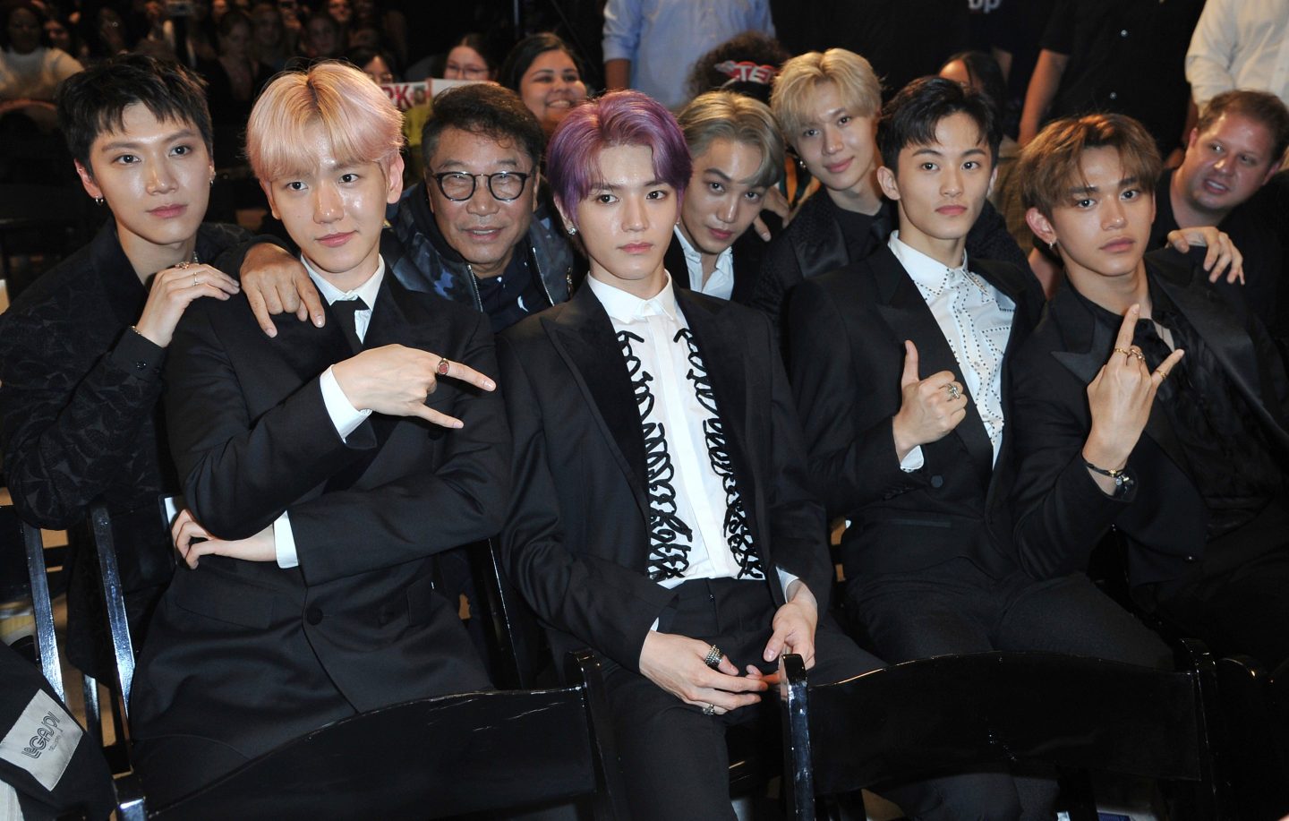 Producer Lee Soo Man, third from left, and members of SuperM, from left, Ten, Baekhyun, Taeyong, Kai, Taemin, Mark and Lucas sit in the audience to watch the premiere of their music video for their song "Jopping" during a media conference on Oct. 3, 2019, at Capitol Studios in Los Angeles.