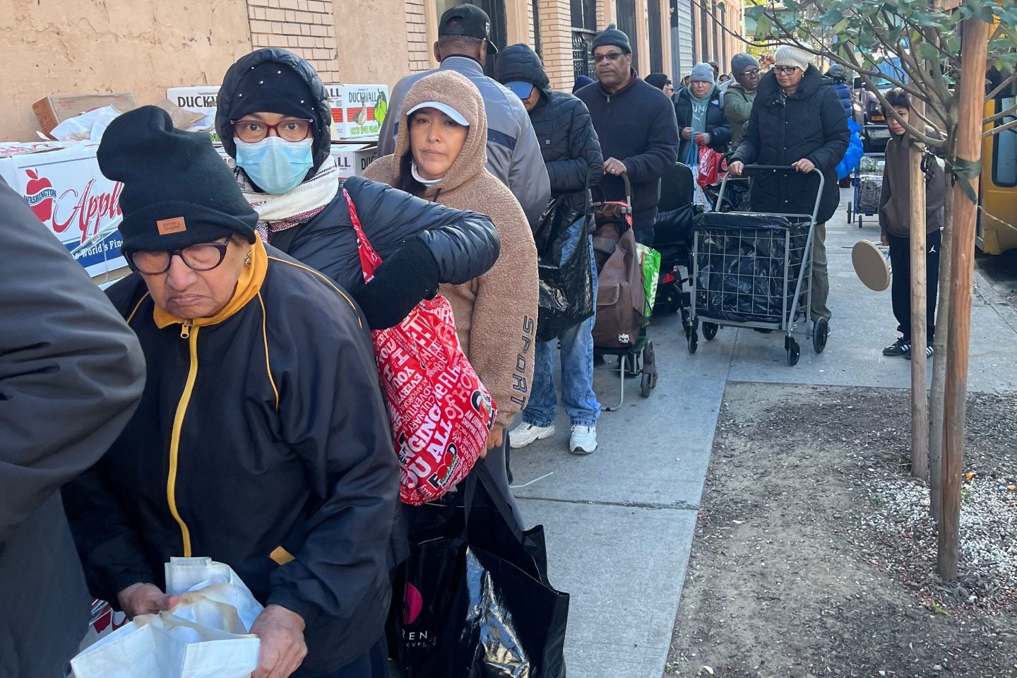 People wait in line for free food at the World of Life Christian Fellowship International food pantry in the Bronx borough of New York on Saturday, Nov. 1, 2025.