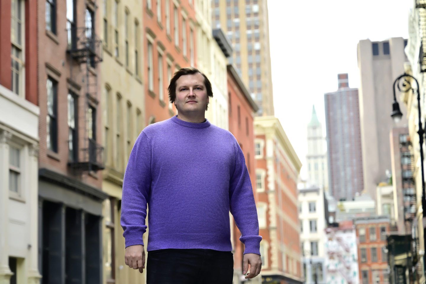 Stani Kulechov stands in NYC with backdrop of buildings.