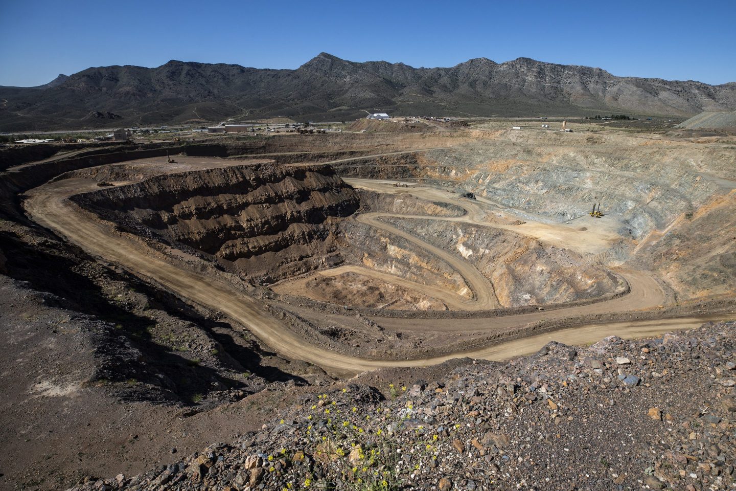 Mining equipment sits inside the pit at the Mountain Pass mine, operated by MP Materials, in Mountain Pass, California, U.S. America&#039;s top rare earths producer, MP Materials, is expanding its vertical integration of mining and magnets production in the U.S. after years of shipping its output to China because there was no refining capacity available to handle its production. Photographer: Joe Buglewicz/Bloomberg via Getty Images