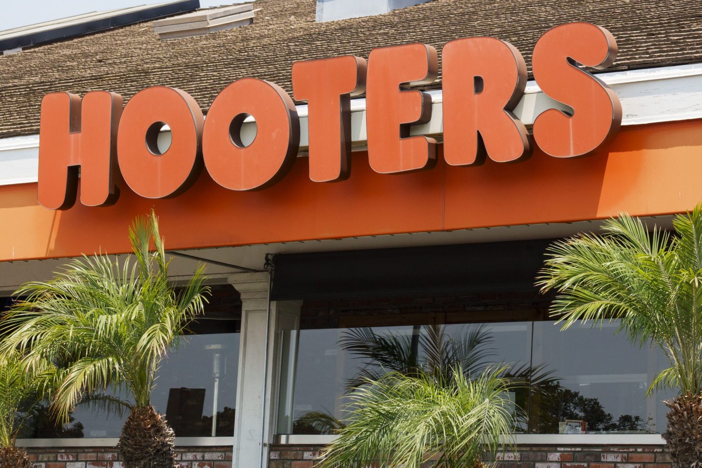 A building has a sign reading "HOOTERS" in bright orange letters
