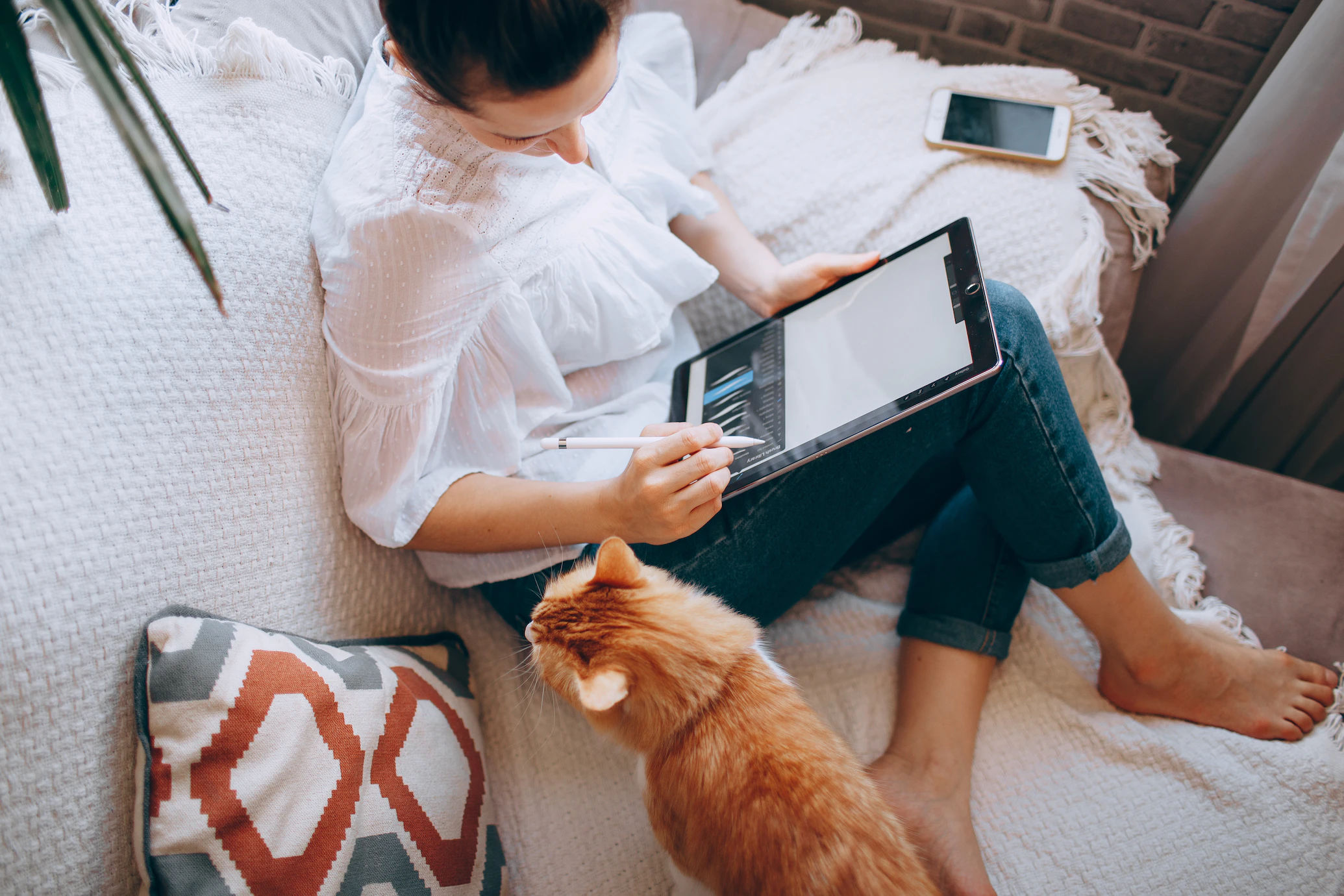 woman working from home with a cat next to her