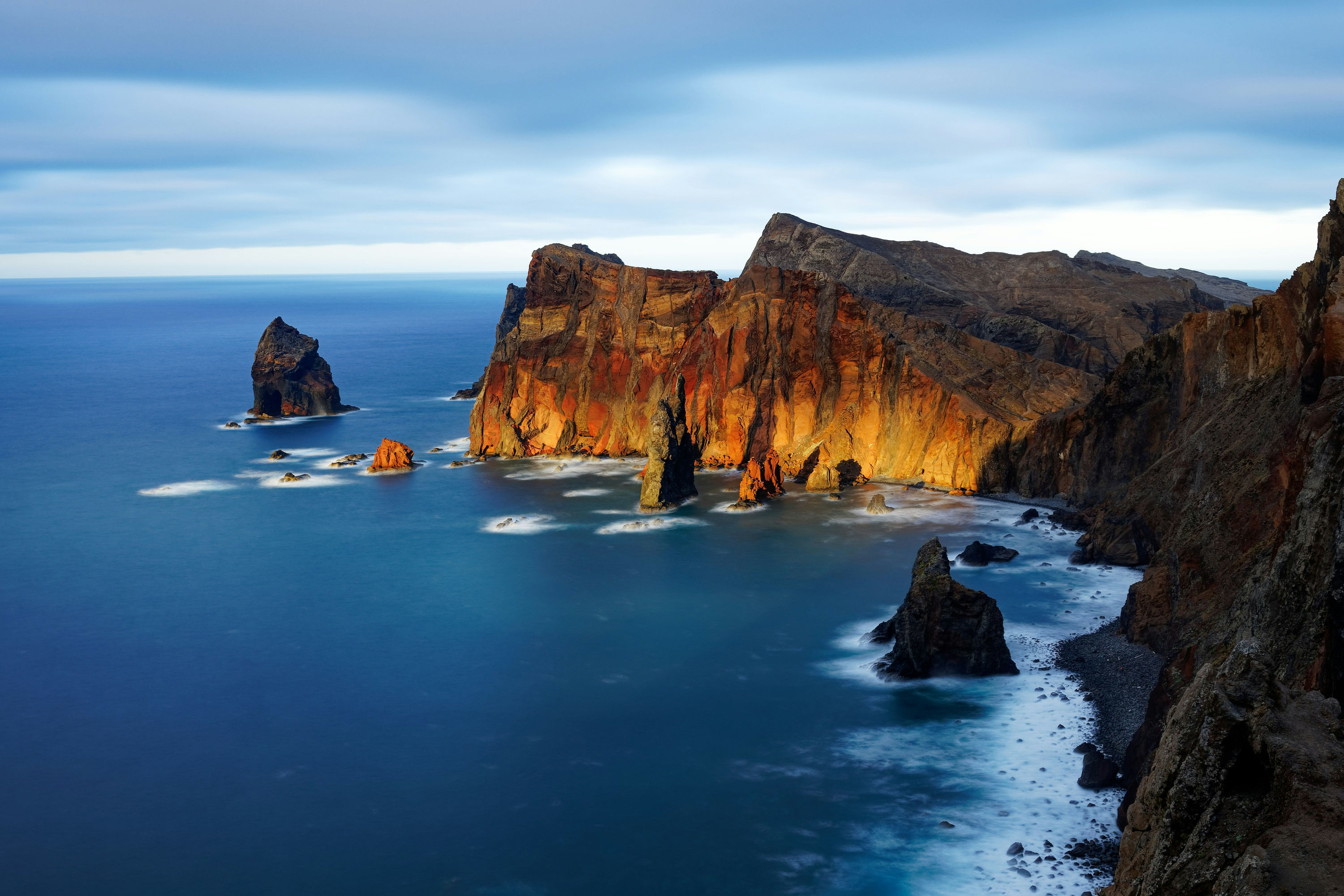 The volcanic cliffs and sea stacks of Ponta de São Lourenço at sunset.
