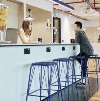 Man sitting at bar being served by bartender with blue bar stools