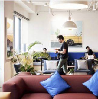 Private office with people spread out and nice couch in foreground