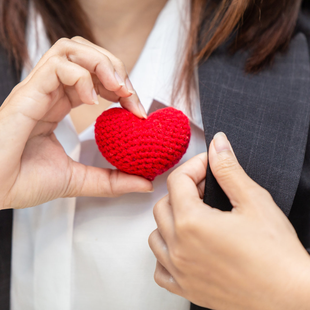 a woman holding a stuffed toy heart