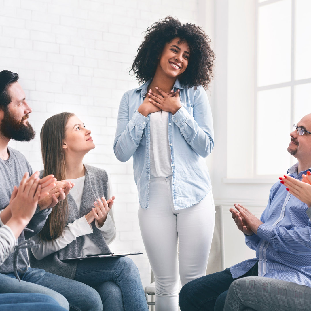 employees clapping at a woman