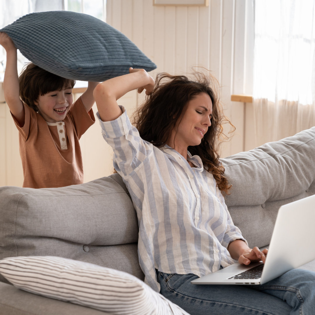 a child annoying his mom while working