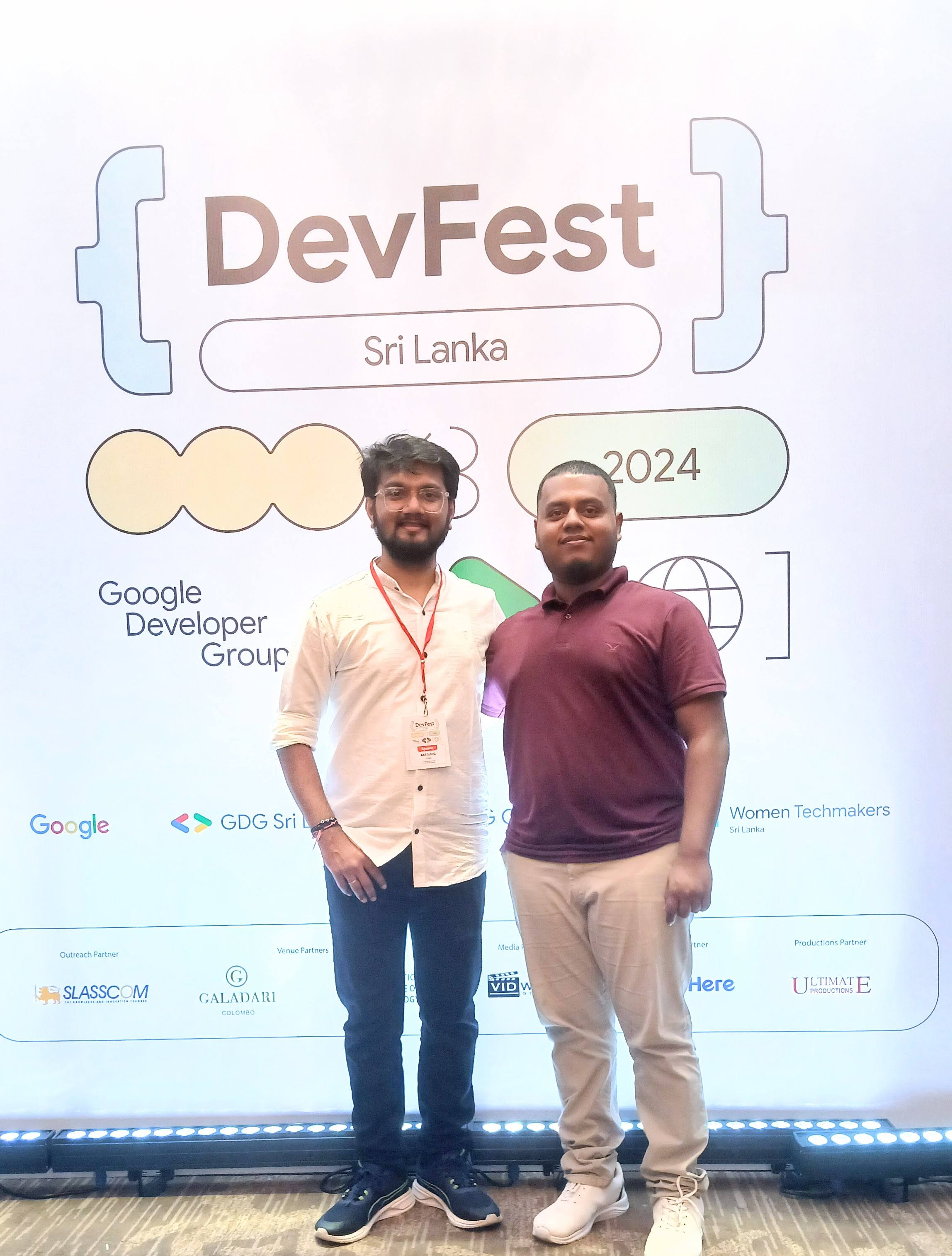 Aweesha Wijesundara with another attendee in front of the DevFest Sri Lanka 2024 backdrop