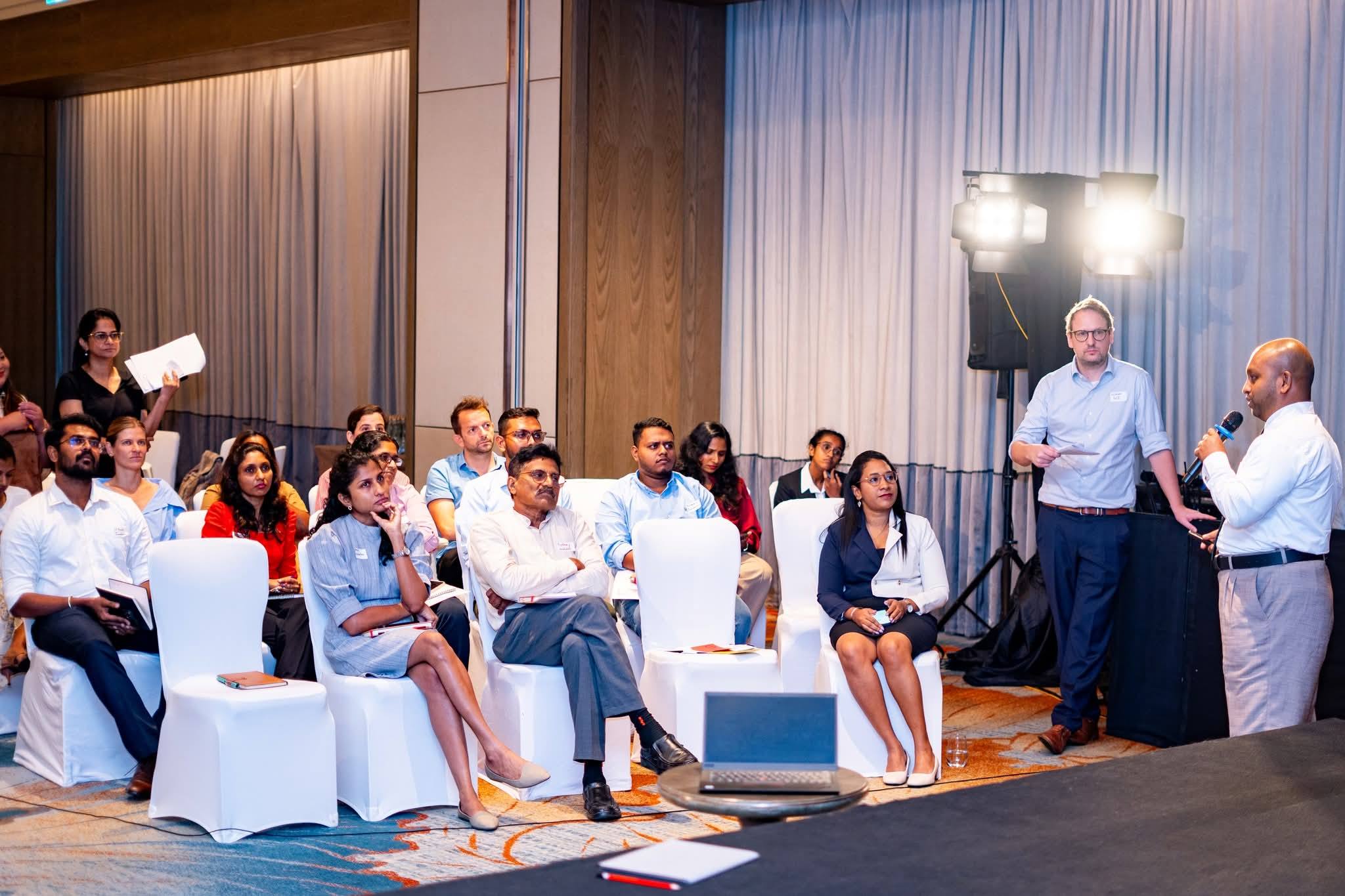 A speaker with a microphone presenting to seated participants at the GIZ and Hatch incubator programme