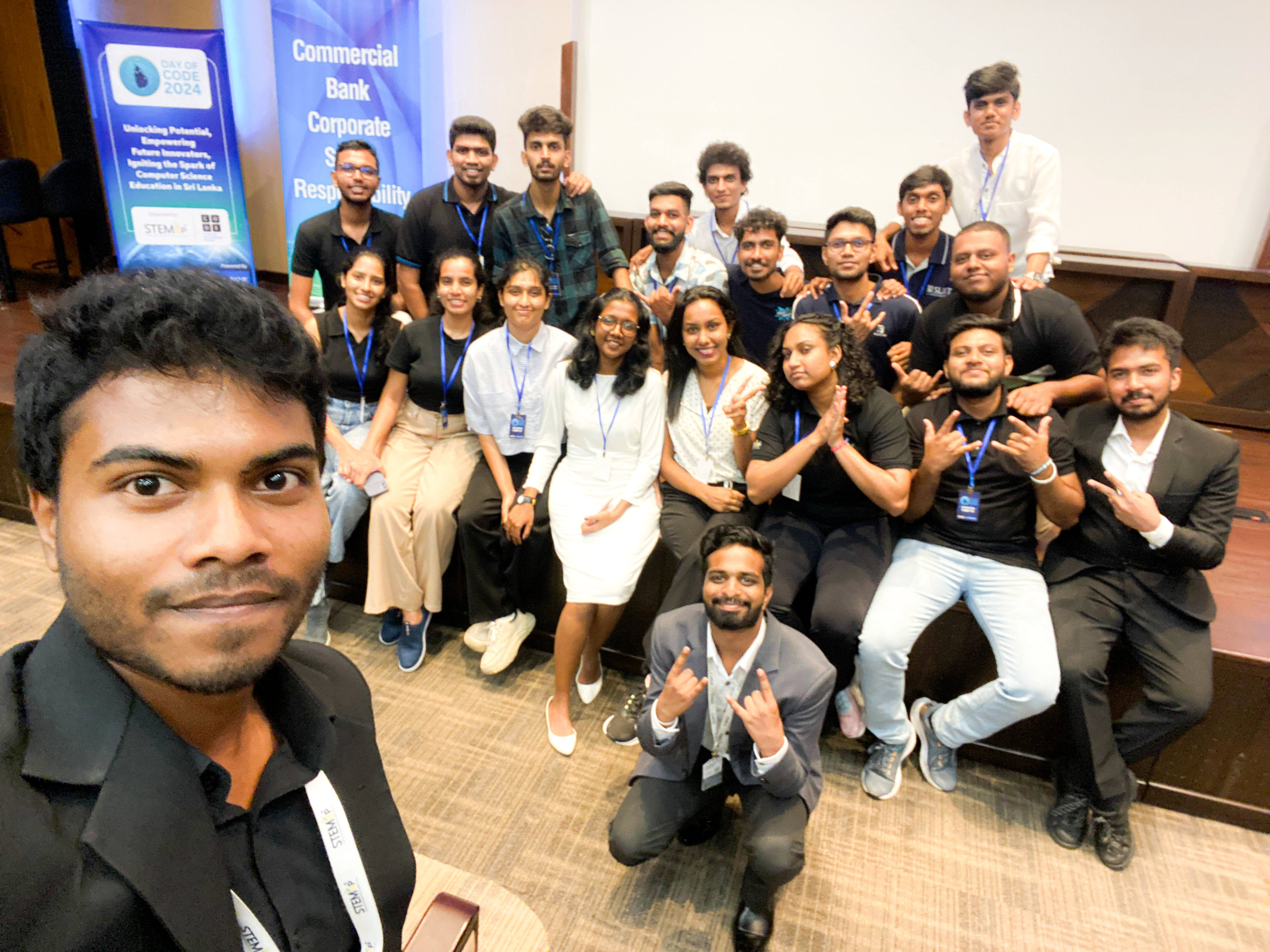 A selfie of Aweesha Wijesundara's Day of Code 2024 team gathered at the front of a hall