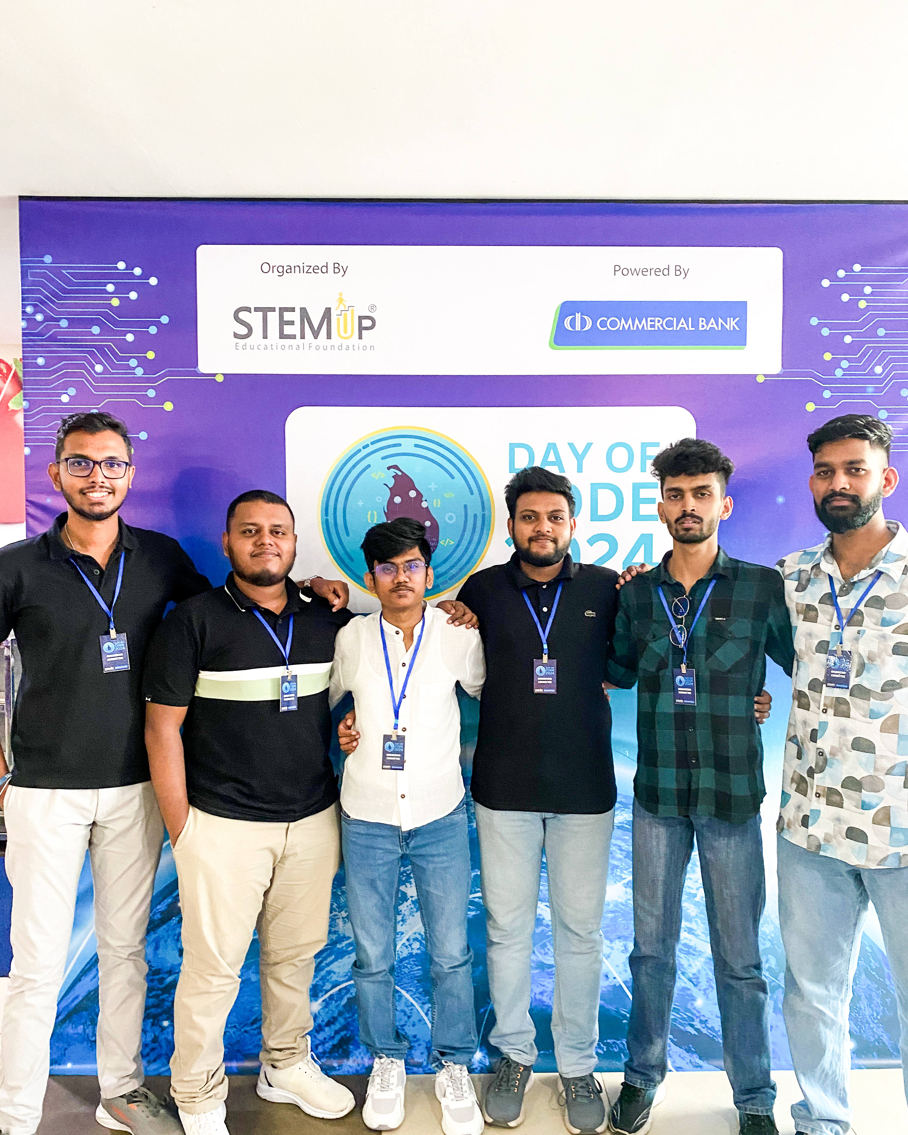 Aweesha Wijesundara with fellow team members in front of the STEMUP Day of Code 2024 backdrop