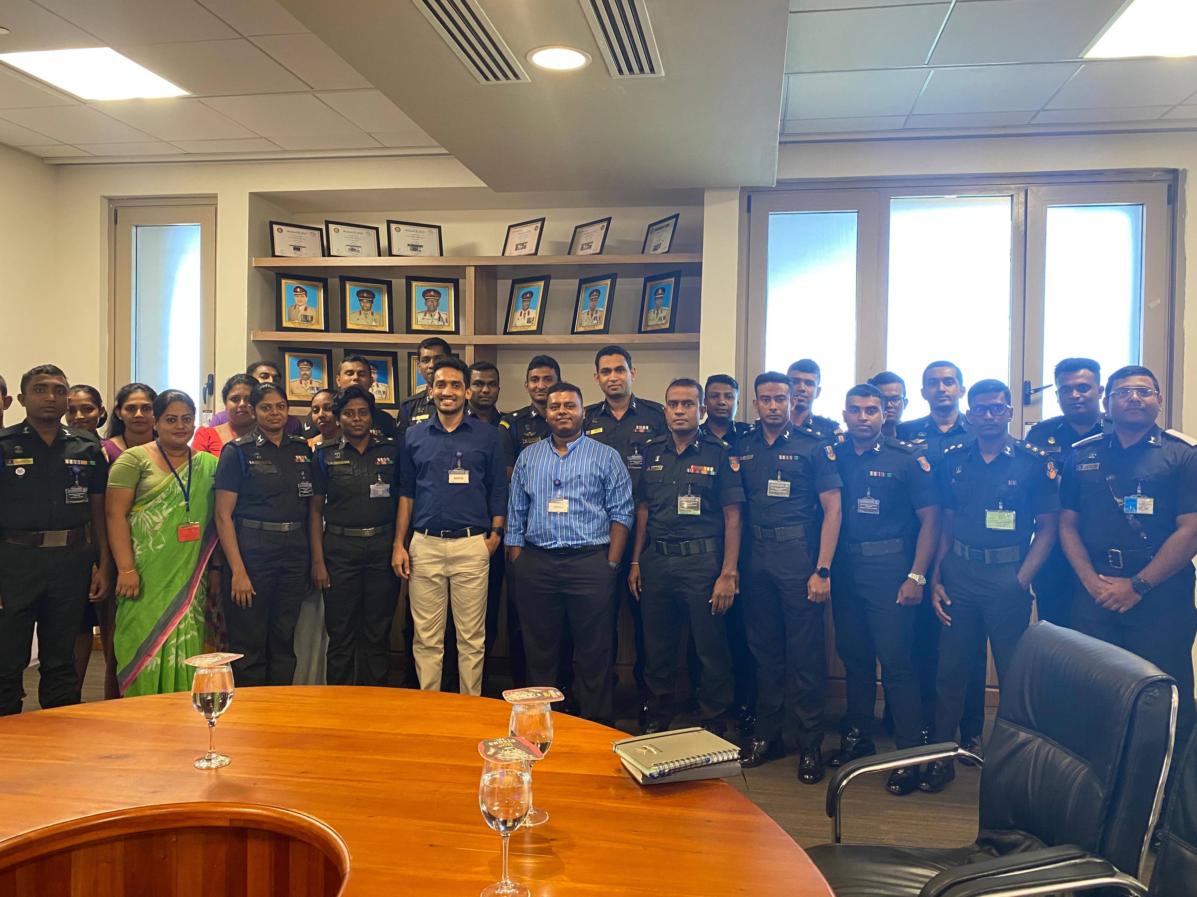 Aweesha Wijesundara with uniformed participants of the AI session around a conference table at the Defence Headquarters Complex