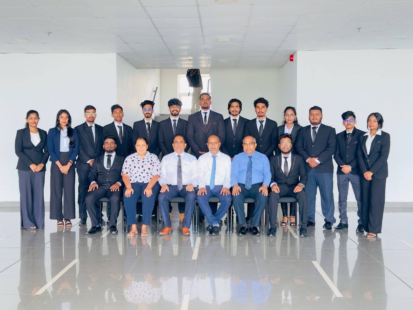Aweesha Wijesundara with the 2025–2026 SLIIT FCMU Media Unit team in formal wear, standing behind seated professors