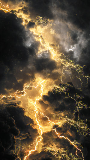 Dark storm clouds illuminated by bright golden lightning bolts and glowing embers in a dramatic sky
