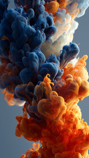 A close-up of swirling blue and orange ink in water forming fluid art patterns with dynamic abstract plumes.