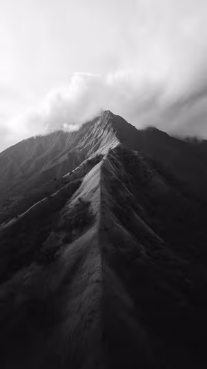 Minimalist mountain ridge centered on a black and white background in a moody aesthetic.