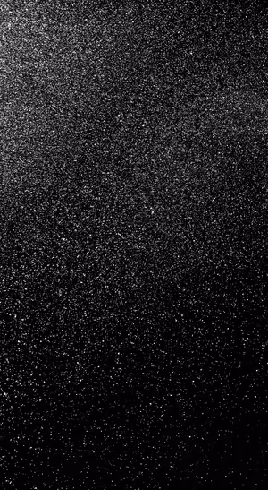 Minimalist black glitter texture on a black background in a monochrome aesthetic.