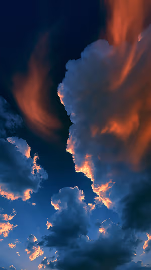 Cinematic clouds centered on a deep blue sky with fiery orange backlit edges ultra HD 8K sky background.