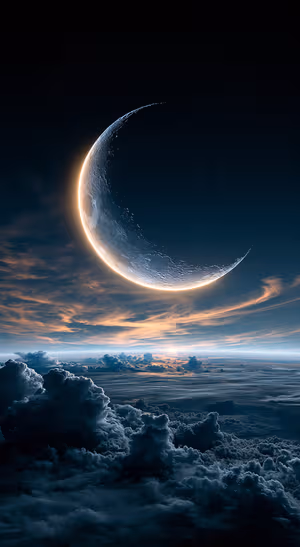 Celestial crescent moon above dark blue clouds in a dramatic night sky aesthetic.