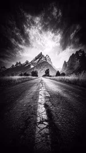 Moody black and white mountain road leading toward snowy peaks on a monochrome background in a dramatic, cinematic aesthetic.