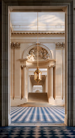 Neoclassical hall in an ornate architectural style with beige walls and a blue checkerboard floor.