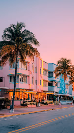 Pastel Art Deco Ocean Drive scene with neon lit facades and palm trees under a pink sky ultra hd background