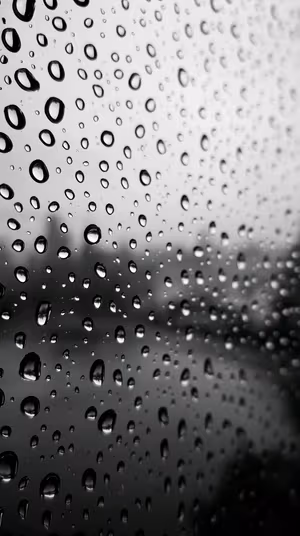 Minimalist monochrome raindrops on glass centered on a gray black background in a moody photographic aesthetic, ultra HD