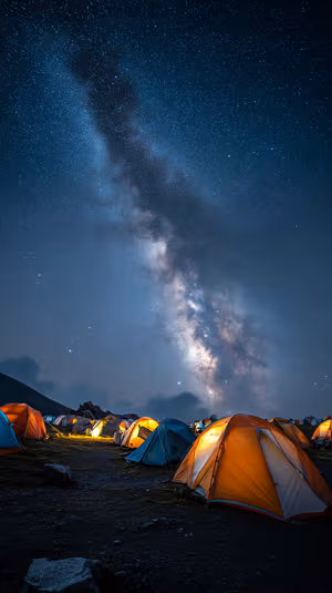 Astro photography Milky Way campsite centered on a midnight blue sky with glowing tents ultra HD night sky background.