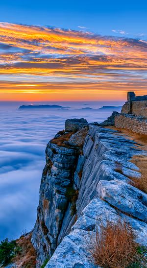 Scenic cliff landscape centered on a blue background in a golden sunset aesthetic.